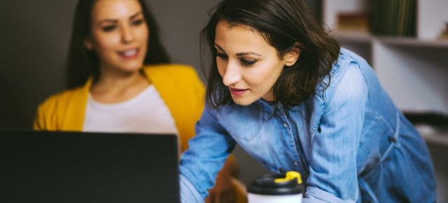 une collaboratrice aide une collegue